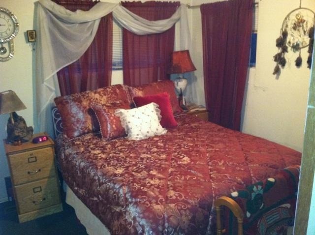 5298 Show Low Lake Road Lakeside, AZ 85929 - Photo 19 of 36 a large bed sitting in a bedroom next to a window and a chandelier