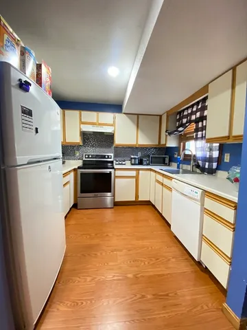 a kitchen with stainless steel appliances granite countertop a stove a sink and a refrigerator