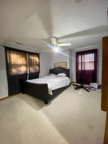 a spacious bedroom with a bed and a chandelier
