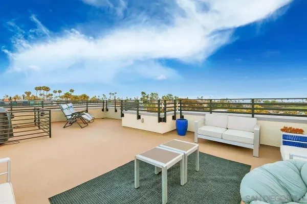a view of a terrace with lawn chairs