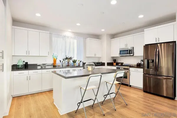 a kitchen with white cabinets and stainless steel appliances