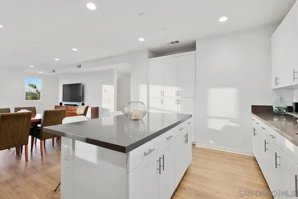 a kitchen with stainless steel appliances granite countertop a sink dishwasher a stove and a refrigerator with wooden floor
