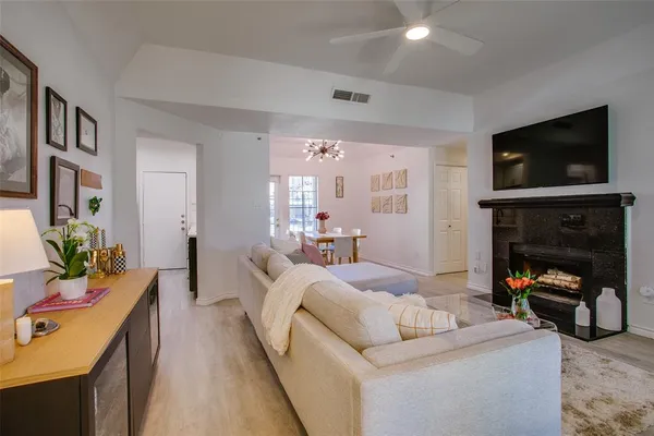 a living room with furniture a flat screen tv and a fireplace