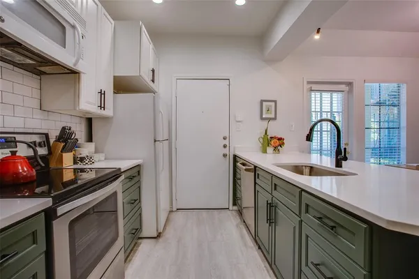a kitchen with stainless steel appliances a sink stove and refrigerator