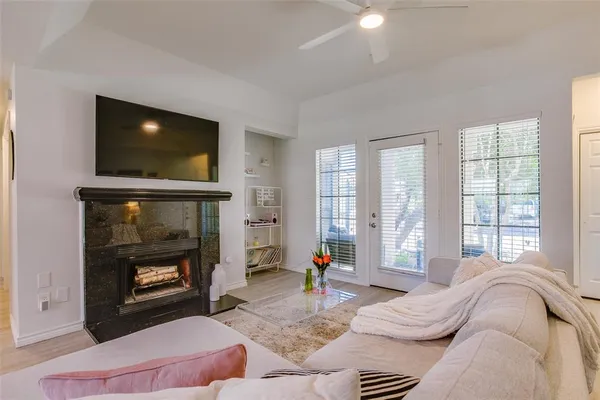 a living room with furniture a flat screen tv and a fireplace
