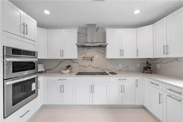 a kitchen with white cabinets and stainless steel appliances