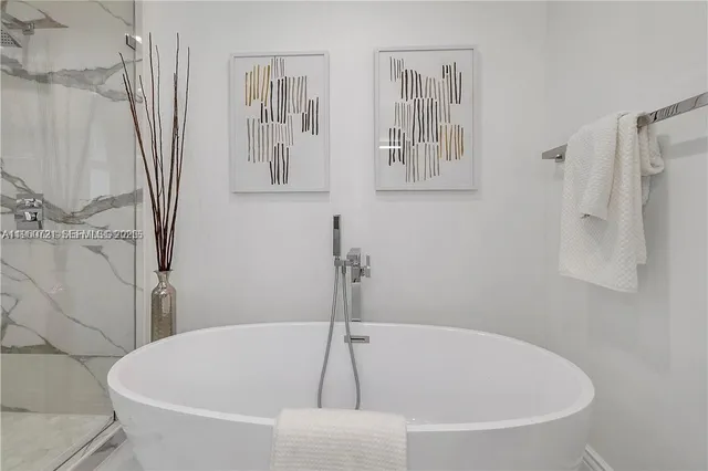 a white bath tub sitting next to a shower