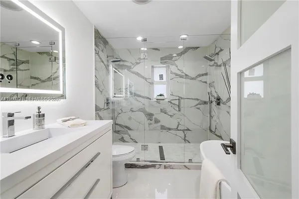 a bathroom with a sink mirror and a shower