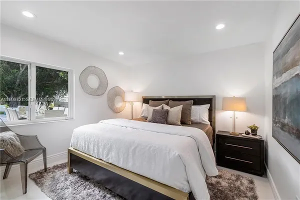 a bedroom with bed and a large window with outer view