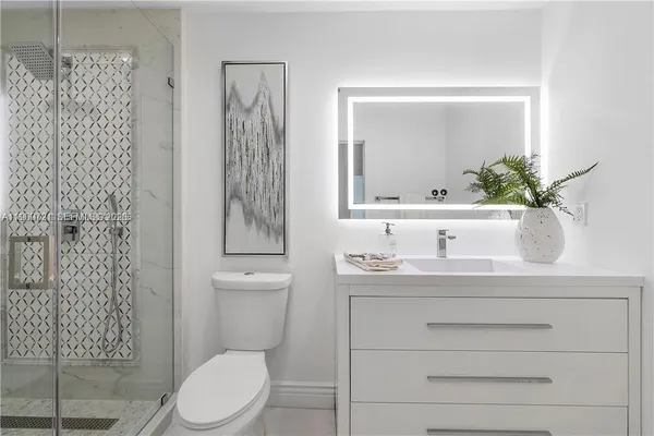 a bathroom with a granite countertop sink a toilet and mirror