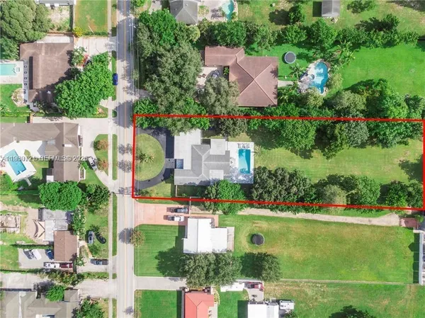 an aerial view of a house with a yard and lake view