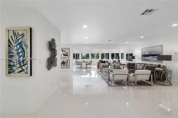 a living room with lots of furniture and view of kitchen