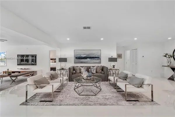 a living room with furniture wooden floor and a lamp