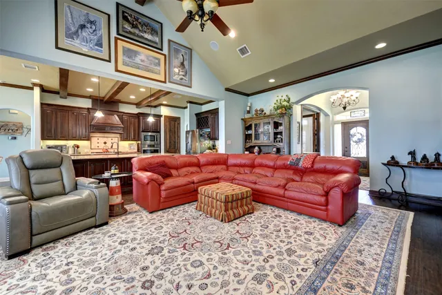 a kitchen with stainless steel appliances granite countertop a table chairs and a refrigerator