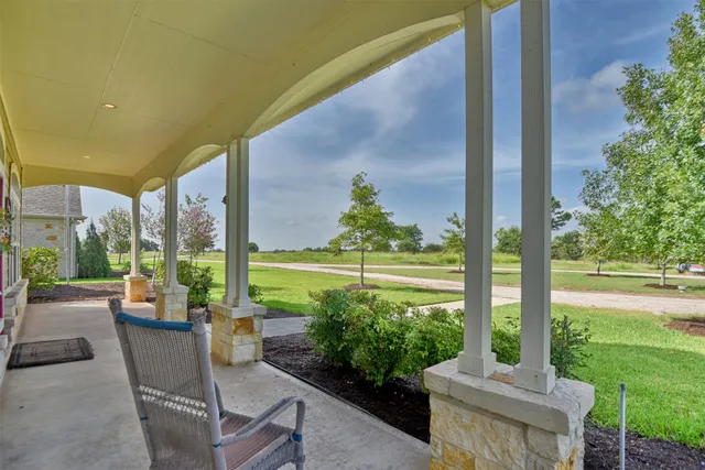a view of a porch with chairs and backyard