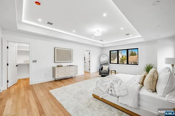 a spacious bedroom with a bed and glass table