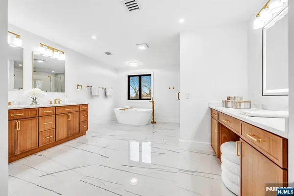 a spacious bathroom with a double vanity sink mirror and shower
