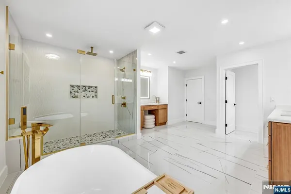 a spacious bathroom with a double vanity sink a mirror and a shower