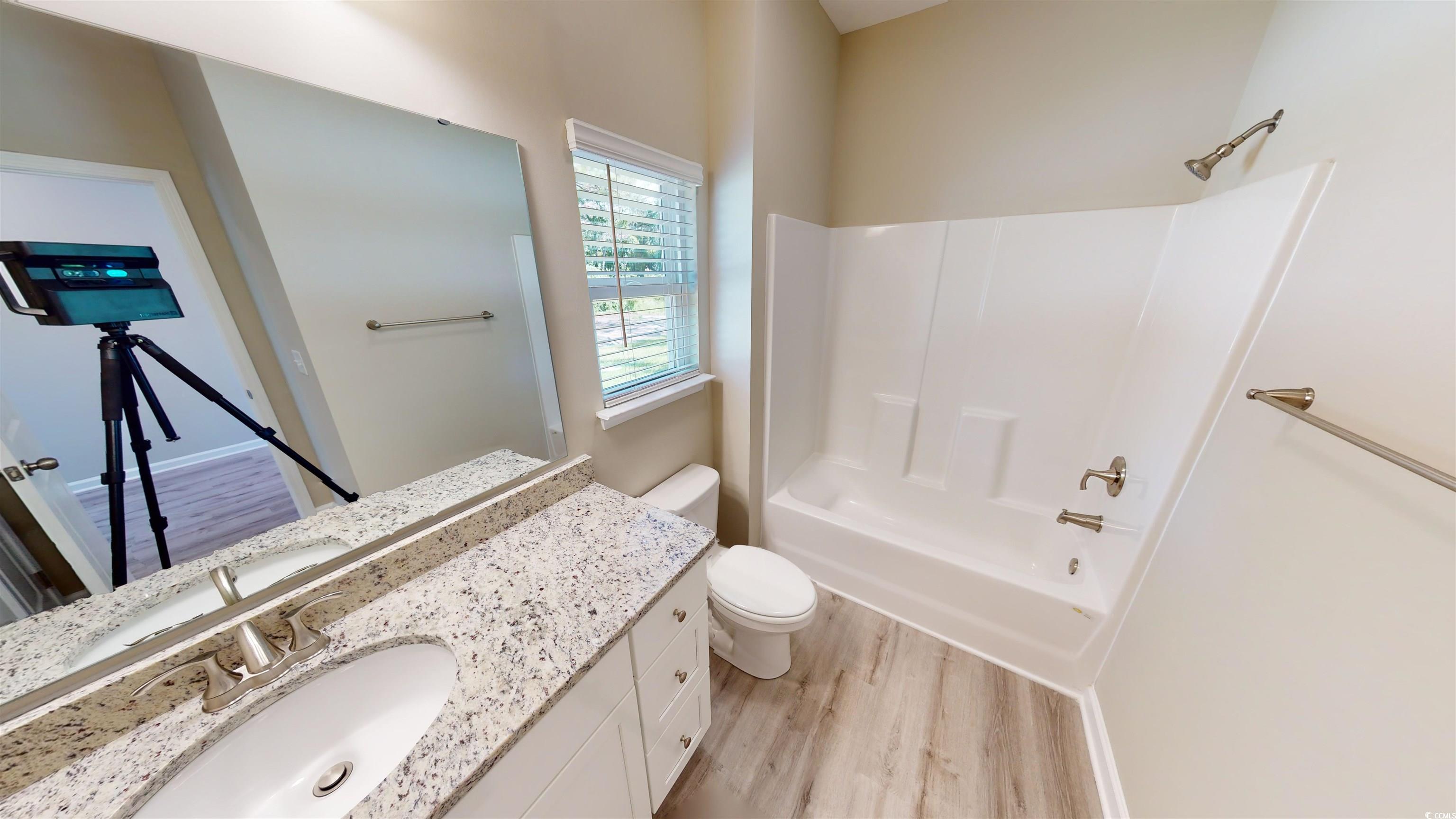 84 Racquet Club Drive, Unit WVC 14 Pawleys Island, SC 29585 - Photo 4 of 26 Full bath featuring light wood-type flooring, vanity, and bathtub / shower combination