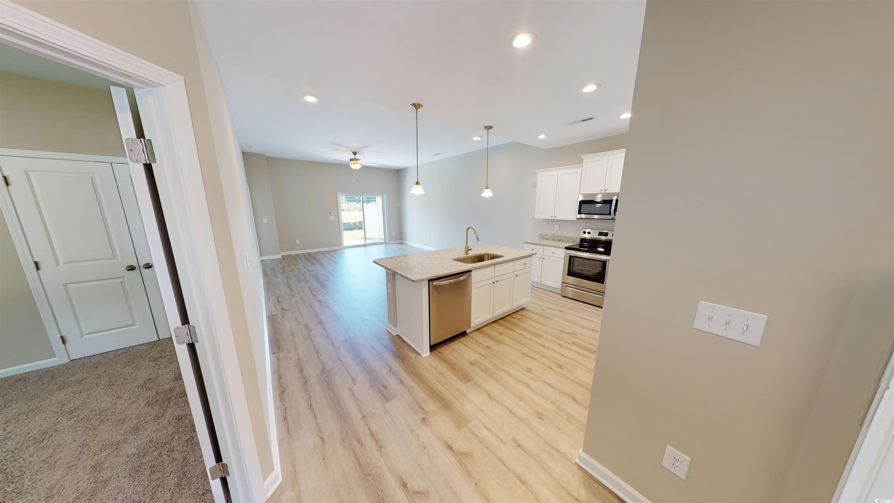 84 Racquet Club Drive, Unit WVC 14 Pawleys Island, SC 29585 - Photo 24 of 26 Kitchen with open floor plan, white cabinets, a kitchen island with sink, recessed lighting, and decorative light fixtures