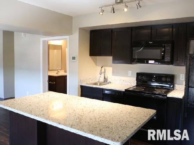 501 15th Street, Unit 504 Moline, IL 61265 - Photo 2 of 5 a kitchen with a kitchen island wooden cabinets and black appliances