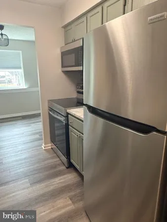 a kitchen with metallic refrigerator and window
