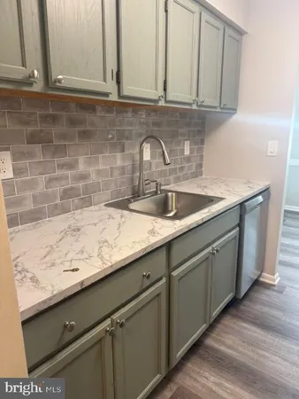 a kitchen with granite countertop a sink and cabinets