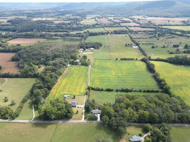 an aerial view of residential houses with outdoor space and lake view