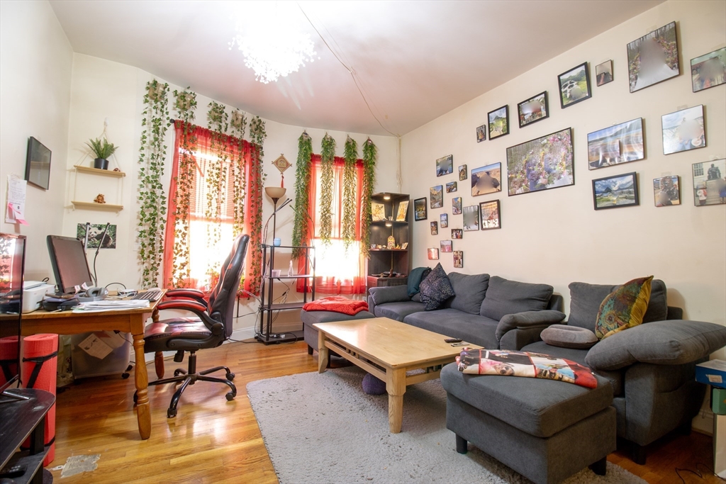 828 Huntington Avenue, Unit 1 Boston, MA 02115 - Photo 1 of 10 a living room with furniture a bookshelf and a window