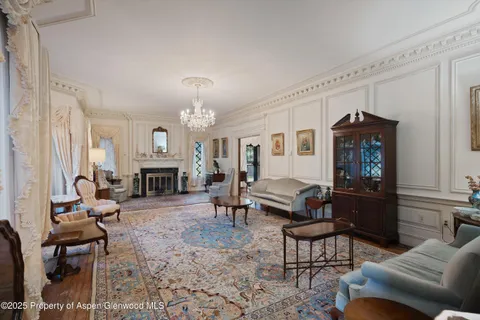 a living room with furniture a fireplace and a chandelier