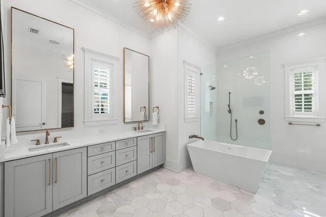 a bathroom with a tub a mirror and a shower