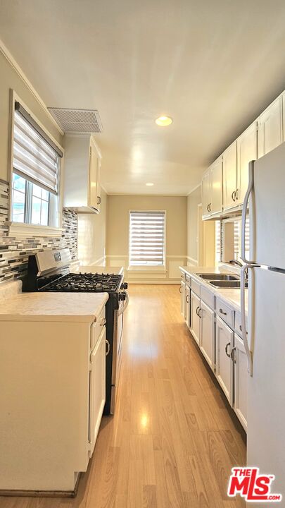 1022 South Norton Avenue, Unit C Los Angeles, CA 90019 - Photo 12 of 43 a kitchen with stainless steel appliances a refrigerator and a stove top oven