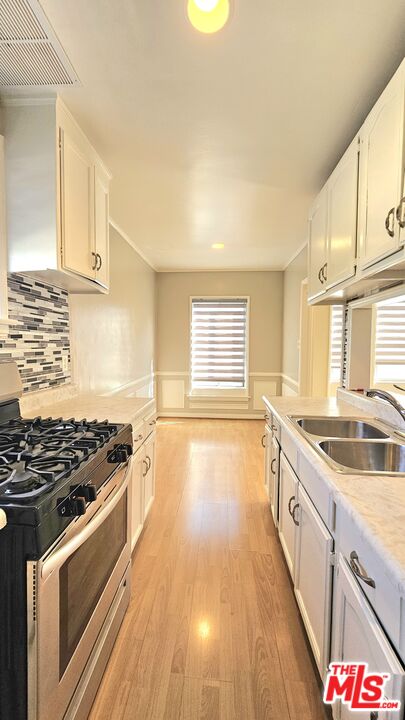 1022 South Norton Avenue, Unit C Los Angeles, CA 90019 - Photo 13 of 43 a kitchen with granite countertop a stove and a sink