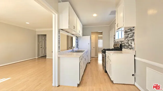 a kitchen with kitchen island sink stove and white cabinets
