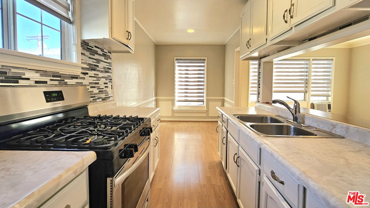 1022 South Norton Avenue, Unit C Los Angeles, CA 90019 - Photo 2 of 43 a kitchen with granite countertop a stove and a sink