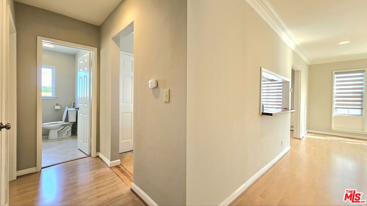 1022 South Norton Avenue, Unit C Los Angeles, CA 90019 - Photo 22 of 43 a view of a hallway with wooden floor and a bathroom