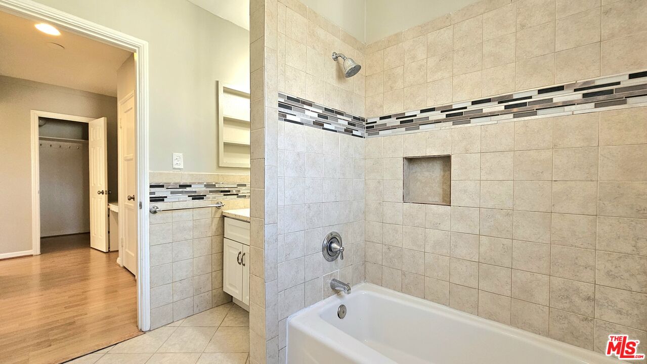 1022 South Norton Avenue, Unit C Los Angeles, CA 90019 - Photo 23 of 43 a bathroom with a bathtub a sink a mirror and a shower