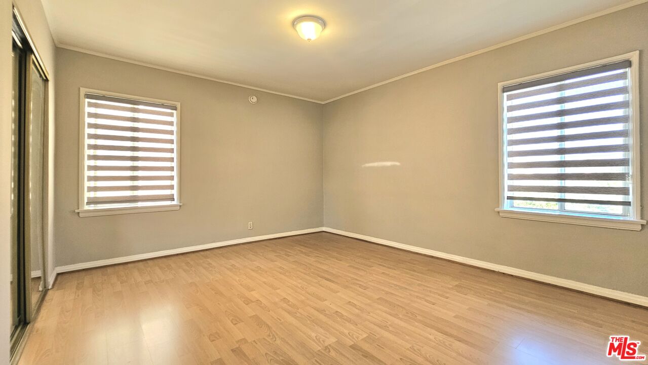 1022 South Norton Avenue, Unit C Los Angeles, CA 90019 - Photo 29 of 43 a view of an empty room with wooden floor and a window