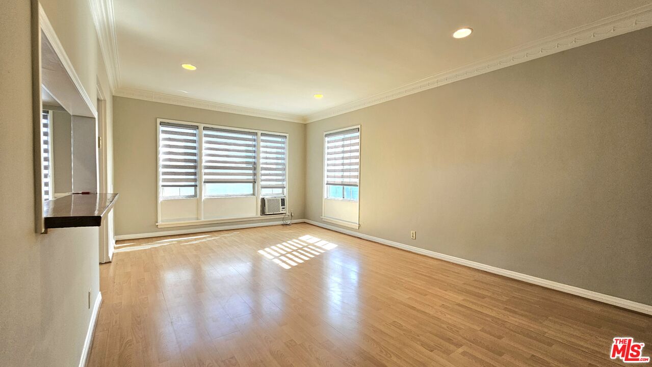 1022 South Norton Avenue, Unit C Los Angeles, CA 90019 - Photo 8 of 43 a view of an empty room with wooden floor and a window