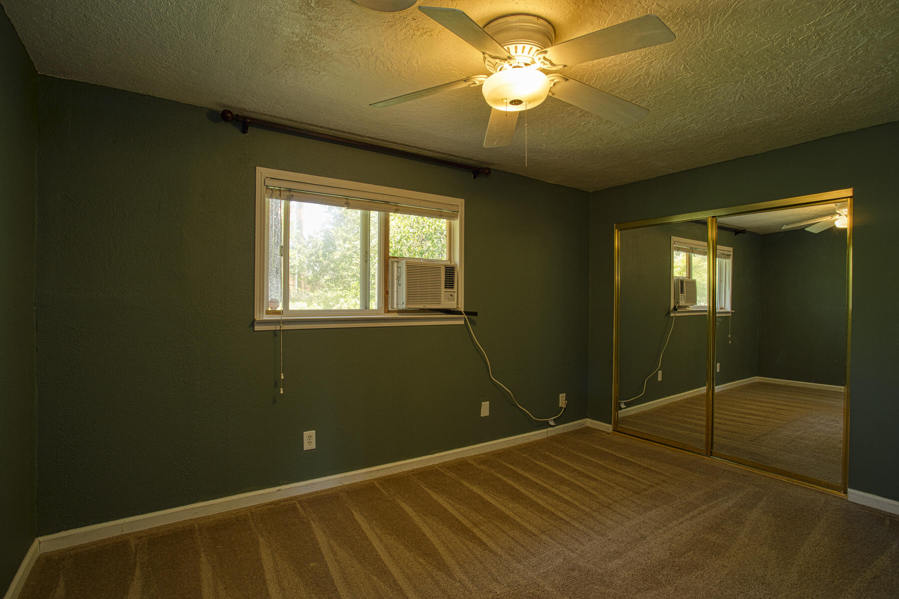 17829 Ranchera Road Shasta Lake, CA 96019 - Photo 12 of 39 a bedroom with a bed and a chandelier