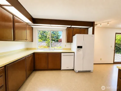 a kitchen with white cabinets and white appliances