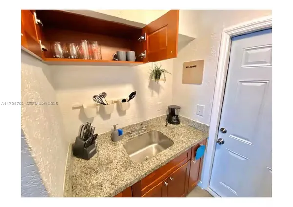 a bathroom with a granite countertop sink a mirror and shower