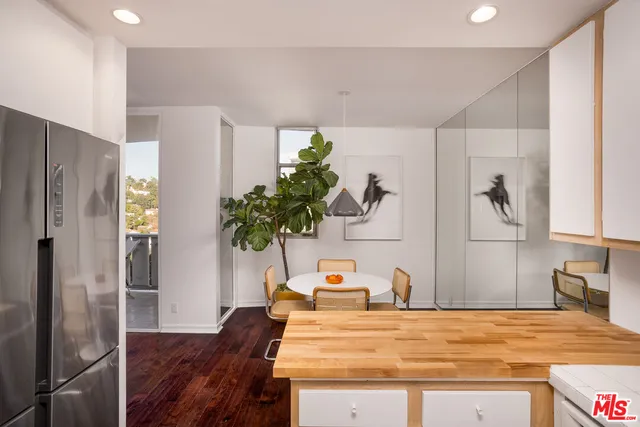 a room with a refrigerator and a wooden floor