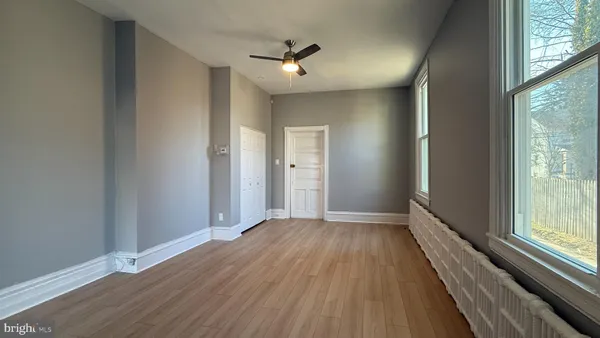 a view of a hallway with wooden floor and a window