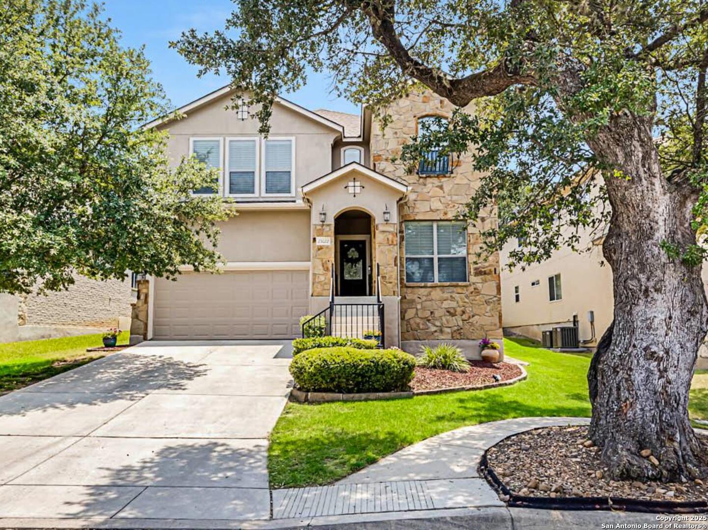 a front view of a house with a yard and trees