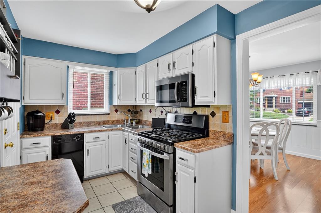 352 Spring Valley Road Pittsburgh, PA 15243 - Photo 6 of 33 a kitchen with granite countertop a stove top oven sink and cabinets