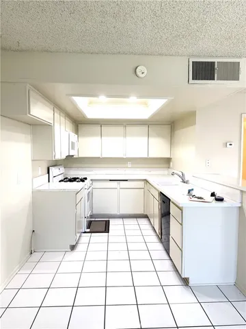 a kitchen with a sink a stove cabinets and counter space