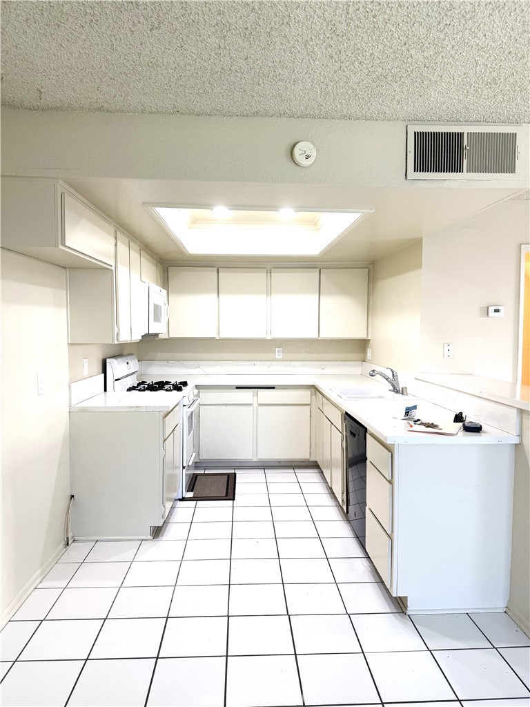 2511 Florida Street, Unit 1 Huntington Beach, CA 92648 - Photo 2 of 13 a kitchen with a sink a stove cabinets and counter space