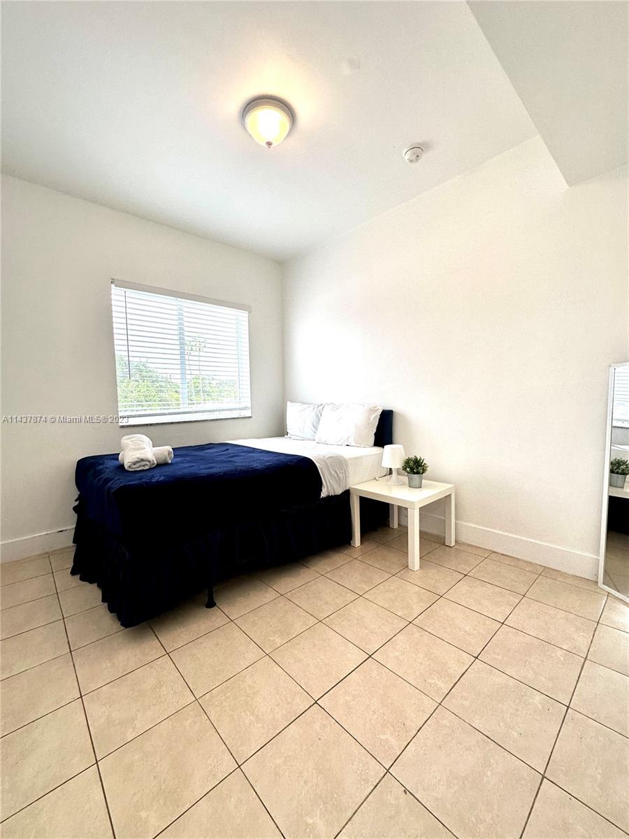1684 Southwest 10th Street Miami, FL 33135 - Photo 10 of 15 a living room with a black white checkered floor and a large window