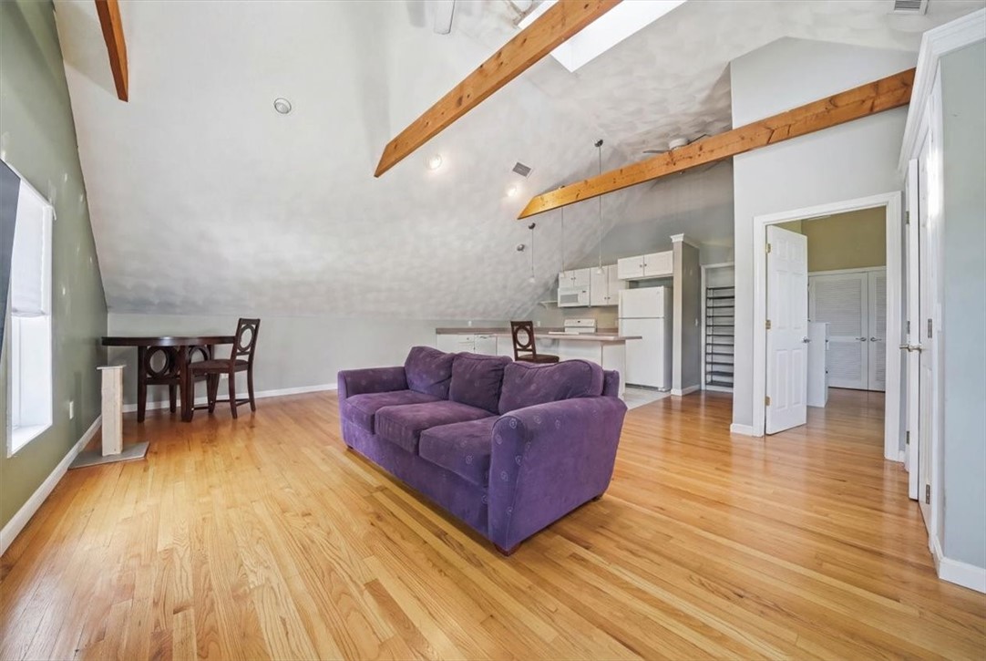 32 Equestrian Way Cranston, RI 02921 - Photo 28 of 50 On the opposite side of the apartment, an open-concept kitchen and living space features soaring vaulted ceilings and exposed beams.